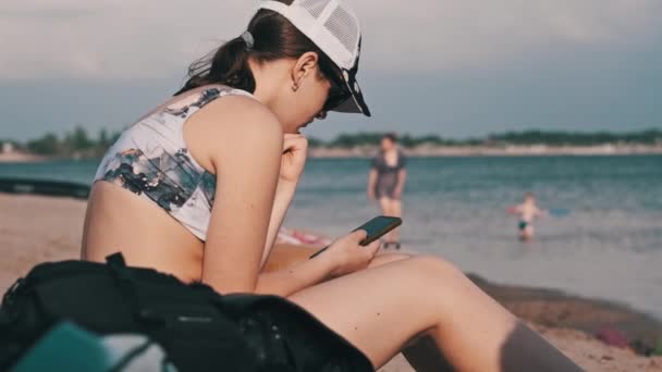 Bella Ragazza Costume Bagno Siede Una Spiaggia Sabbia Con Telefono — Video Stock