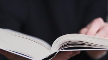 Kitap okumak ve sayfaları çevirmek, kapat. Genç adam bir kitap tutuyor ve sayfaları çeviriyor, ağır çekimde. Tanımlanamayan bir adam kitap okuyor ve sayfaları karıştırıyor. Kendi kendini eğitme