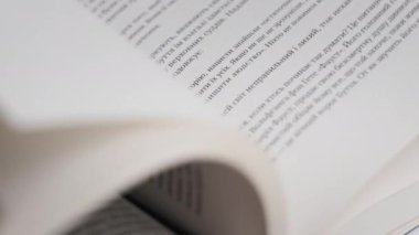 Kitap çevirme sayfaları, yakın çekim, yavaş çekim. Erkek eli bir kitabın sayfalarını karıştırır, seçici odaklanma. Kalın bir kitabın sayfalarını hızlıca çeviriyorum. Ayrıntılı görüş. Okuma, öğrenme, kendini eğitme.