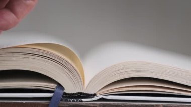 Kitap çevirme sayfaları, yakın çekim, yavaş çekim. Erkek eli bir kitabın sayfalarını karıştırır, seçici odaklanma. Kalın bir kitabın sayfalarını hızlıca çeviriyorum. Ayrıntılı görüş. Okuma, öğrenme, kendini eğitme.