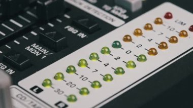 LED indicator of sound level signal on the mixing console. LED strip in green and yellow on output level indicator. Volume level changes of indicator lights. VU meters on the analog sound desk. Macro