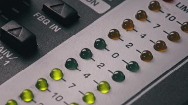 LED indicator of sound level signal on the mixing console. LED strip in green and yellow on output level indicator. Volume level changes of indicator lights. VU meters on the analog sound desk. Macro