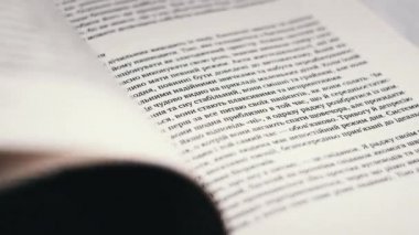 Kitap çevirme sayfaları, yakın çekim, yavaş çekim. Erkek eli bir kitabın sayfalarını karıştırır, seçici odaklanma. Kalın bir kitabın sayfalarını hızlıca çeviriyorum. Ayrıntılı görüş. Okuma, öğrenme, kendini eğitme.