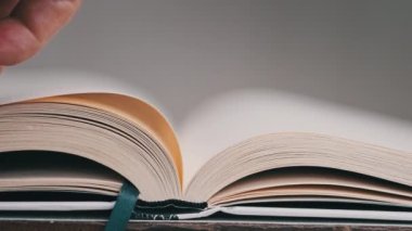 Kitap çevirme sayfaları, yakın çekim, yavaş çekim. Erkek eli bir kitabın sayfalarını karıştırır, seçici odaklanma. Kalın bir kitabın sayfalarını hızlıca çeviriyorum. Ayrıntılı görüş. Okuma, öğrenme, kendini eğitme.