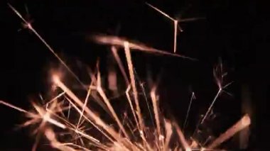 Sparks from a sparkler on a black background. Welding particles, hot metal particles from a working tool. Background abstract gunpowder sparks for text, copyspace. Grinder sparks flying pattern.