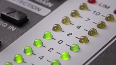 LED indicator of sound level signal on the mixing console. LED strip in green and yellow on output level indicator. Volume level changes of indicator lights. VU meters on the analog sound desk. Macro