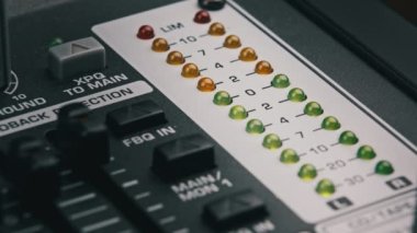 LED indicator of sound level signal on the mixing console. LED strip in green and yellow on output level indicator. Volume level changes of indicator lights. VU meters on the analog sound desk. Macro