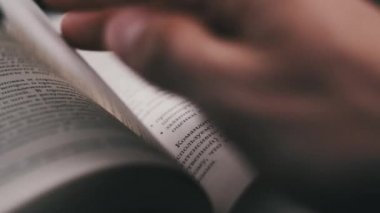 Kitap çevirme sayfaları, yakın çekim, yavaş çekim. Erkek eli bir kitabın sayfalarını karıştırır, seçici odaklanma. Kalın bir kitabın sayfalarını hızlıca çeviriyorum. Ayrıntılı görüş. Okuma, öğrenme, kendini eğitme.