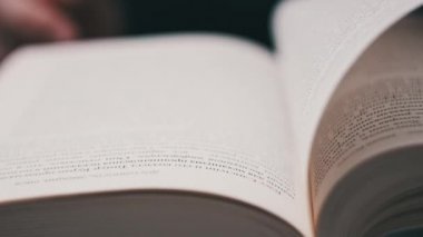 Kitap çevirme sayfaları, yakın çekim, yavaş çekim. Erkek eli bir kitabın sayfalarını karıştırır, seçici odaklanma. Kalın bir kitabın sayfalarını hızlıca çeviriyorum. Ayrıntılı görüş. Okuma, öğrenme, kendini eğitme.