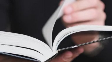 Kitap okumak ve sayfaları çevirmek, kapat. Genç adam bir kitap tutuyor ve sayfaları çeviriyor, ağır çekimde. Tanımlanamayan bir adam kitap okuyor ve sayfaları karıştırıyor. Kendi kendini eğitme