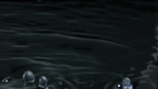 许多水滴以慢动作落在水面上 宏观一击 液滴的雨落在液体表面 形成波浪 圆圈和液体的湍流 表面张力 240 Fps — 图库视频影像