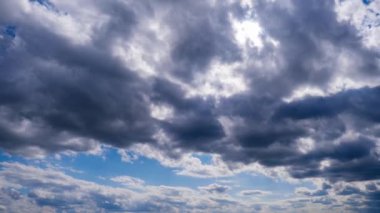 Katmanlı bulutların zaman akışı parlak güneşin altında mavi gökyüzünde ilerler. Cirrus bulutları şekil değiştirir ve bulut uzayında çözünür. Görkemli pofuduk gökyüzü. Bulutlu zaman çizelgesi. Hava değişimi. İnanılmaz doğa 4K