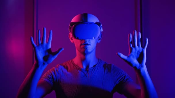 Man Virtual Reality Helmet Illuminated Red Blue Plays Game Young – stockvideo
