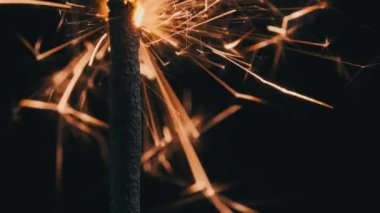 Sparkler on the black background in slow motion, macro shot. Lightening sparkler concept. Bengal light is burning in dark. Close-up of firework sparkler burning. Gun powder sparks shot.