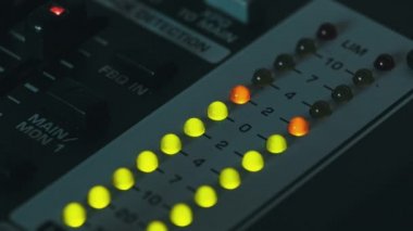 LED indicator of sound level signal on the mixing console. LED strip in green and yellow on output level indicator. Volume level changes of indicator lights. VU meters on the analog sound desk. Macro