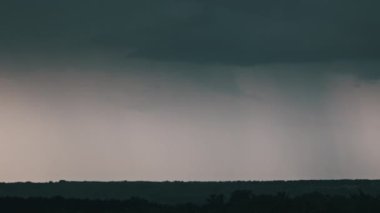 Fırtına bulutlarında şimşek çakıyor. Şiddetli bulutlar birden fazla şimşek ve fırtına patlaması getirir. Orman ufkunun üzerinde akşam vakti büyük yıldırımlar düşüyor. Ağır çekim. 4K
