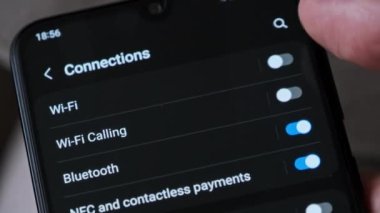 Akıllı bir telefondan Wi-Fi 'ı açıp kapatmak. Kablosuz ağ düğmesi bağlantı menüsündeki cep telefonunu açar. Erkek parmak dokunuşu ekranda modern akıllı telefonda ekranda wi fi bölgesi ekranda.