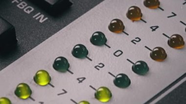 LED indicator of sound level signal on the mixing console. LED strip in green and yellow on output level indicator. Volume level changes of indicator lights. VU meters on the analog sound desk. Macro