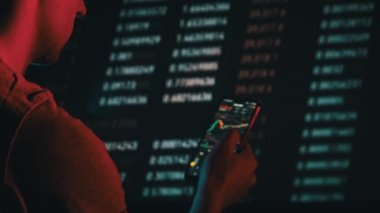 Yatırımcı, değiş tokuş sırasında akıllı telefon ekranındaki kripto para birimini kontrol ediyor. Birçok şifreli varlık fiyatları değiştirir. Döviz kurlarının borsa tabloları. İşadamı dijital borsa yatırımlarını analiz ediyor