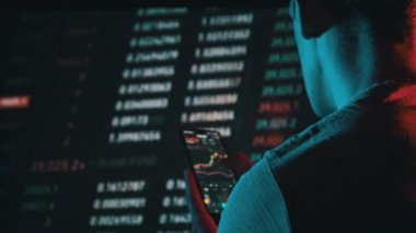 Yatırımcı, değiş tokuş sırasında akıllı telefon ekranındaki kripto para birimini kontrol ediyor. Birçok şifreli varlık fiyatları değiştirir. Döviz kurlarının borsa tabloları. İşadamı dijital borsa yatırımlarını analiz ediyor
