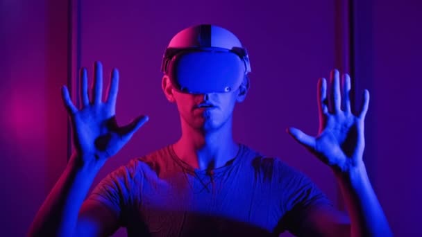 Man Virtual Reality Helmet Illuminated Red Blue Plays Game Young — Vídeos de Stock