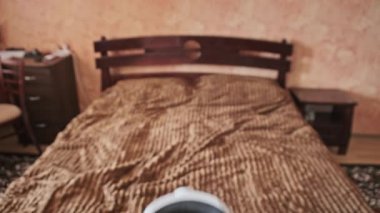 POV of putting on VR glasses virtual reality in the bedroom. Young male hands hold virtual reality helmet indoors. Virtual reality mask. Close-up. Point of view man taking of VR helmet at home.