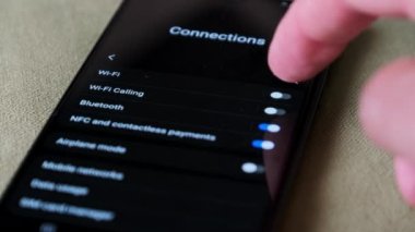 Akıllı bir telefondan Wi-Fi 'ı açıp kapatmak. Kablosuz ağ düğmesi bağlantı menüsündeki cep telefonunu açar. Erkek parmak dokunuşu ekranda modern akıllı telefonda ekranda wi fi bölgesi ekranda.