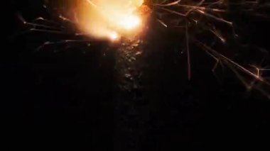 Sparkler on the black background in slow motion, macro shot. Lightening sparkler concept. Bengal light is burning in dark. Close-up of firework sparkler burning. Gun powder sparks shot.