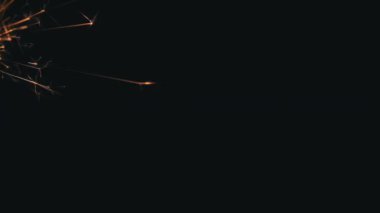 Siyah arka plandaki maytaptan kıvılcımlar. Kaynak parçacıkları, çalışan bir aletin sıcak metal parçacıkları. Arka plan soyut barut kıvılcımları metin ve kopyalanmış uzay için. Öğütücü kıvılcımlar saçar.
