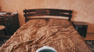 POV of putting on VR glasses virtual reality in the bedroom. Young male hands hold virtual reality helmet indoors. Virtual reality mask. Close-up. Point of view man taking of VR helmet at home.