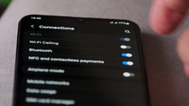 Akıllı bir telefondan Wi-Fi 'ı açıp kapatmak. Kablosuz ağ düğmesi bağlantı menüsündeki cep telefonunu açar. Erkek parmak dokunuşu ekranda modern akıllı telefonda ekranda wi fi bölgesi ekranda.