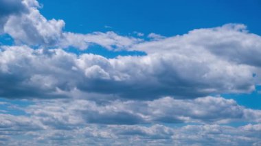 Kümülüs bulutlarının mavi gökyüzünde hareket etme zamanı. Işık katmanlı bulutlar bulut uzayında şekillerini değiştirirler. Harika bir gökyüzü. Bulutların arka planı, zaman atlaması. Uzayı kopyala Hava değişikliği. Doğa. 4K