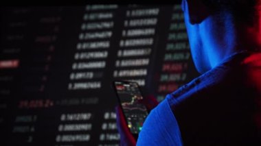 Akıllı telefondaki dijital pazarda kripto fiyat grafiği analizi yapan bir yatırımcı. Kripto para birimi gelecek fiyat öngörüsü konsepti. Ekrana dokunan adam, döviz piyasası verilerine göz atın, yakın plan.