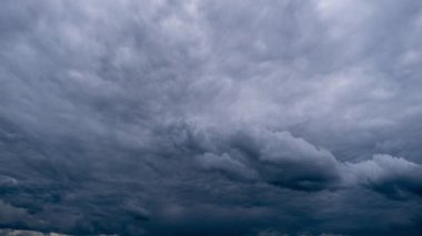 Gökyüzünde hareket eden dramatik fırtına bulutlarının zamanı. Kara kümülüs bulutları bulut uzayında şekillerini değiştirir. Gökyüzü manzaralı. Dramatik atmosfer geçmişi, zaman atlaması. Hava değişikliği. Doğa. 4K