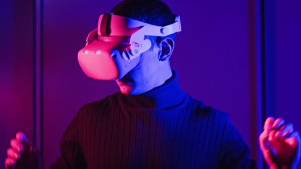 Man Virtual Reality Helmet Illuminated Red Blue Plays Game Young — Vídeos de Stock