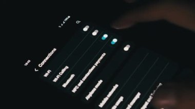 Turning on Wi-Fi on a smartphone. The wifi button is turned on the mobile phone in the connections menu. Male finger hand touching touchscreen on modern smart phone with wi fi zone on screen.