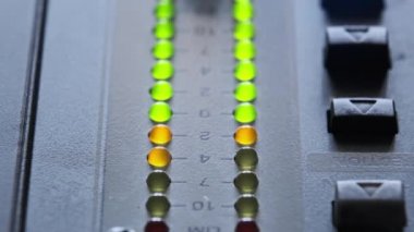 LED indicator of sound level signal on the mixing console. LED strip in green and yellow on output level indicator. Volume level changes of indicator lights. VU meters on the analog sound desk. Macro