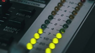 Karıştırma konsolundaki ses seviyesi sinyalinin LED göstergesi. Çıktı seviyesi göstergesinde yeşil ve sarı renkli LED şerit. Ses düzeyi gösterge ışıkları değişiyor. Analog ses masasında VU ölçümleri var. Makro