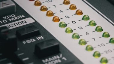LED indicator of sound level signal on the mixing console. LED strip in green and yellow on output level indicator. Volume level changes of indicator lights. VU meters on the analog sound desk. Macro