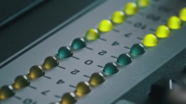 LED indicator of sound level signal on the mixing console. LED strip in green and yellow on output level indicator. Volume level changes of indicator lights. VU meters on the analog sound desk. Macro