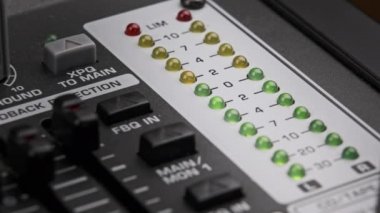 LED indicator of sound level signal on the mixing console. LED strip in green and yellow on output level indicator. Volume level changes of indicator lights. VU meters on the analog sound desk. Macro