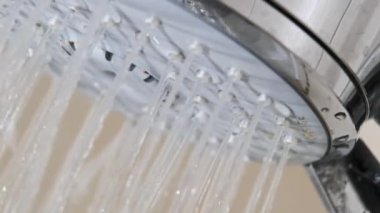 Banyodaki duş başlığından akan su damlalarını yavaş çekimde kapatın. Duş başlığının makro görüntüsü, suyun açılıp kapanması. Yüksek hızlı kamerada musluktan su akıyor. 240fps.