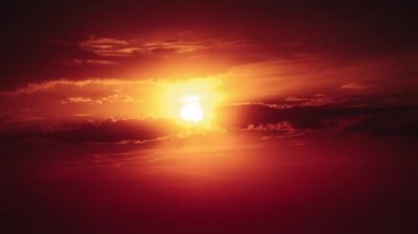 Dramatic sunset with sun rays in the Sky through orange layered clouds, Timelapse. Awesome epic cloud space. The big bright orange sun moves down over the horizon. Time Lapse. Amazing vibrant sundown