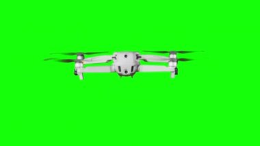 Drone hovering in the air on a green screen. Real quadcopter with camera flights on transparent background. Isolated portable copter on alpha matte. Aircraft blades rotate in hanging. Alpha channel 4K