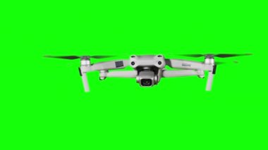 Real quadcopter with camera flights on a green screen. A drone hovering in the air with an alpha channel. Isolated portable copter on alpha matte. Aircraft blades rotate in hanging. Alpha channel 4K