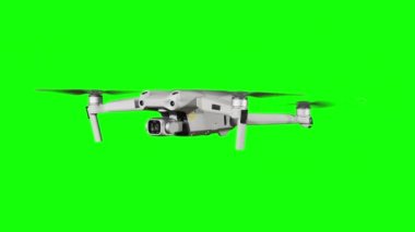 Real quadcopter with camera flights on a green screen. A drone hovering in the air with an alpha channel. Isolated portable copter on alpha matte. Aircraft blades rotate in hanging. Alpha channel 4K