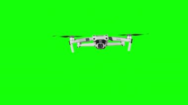 Drone hovering in the air on a green screen. Real quadcopter with camera flights on transparent background. Isolated portable copter on alpha matte. Aircraft blades rotate in hanging. Alpha channel 4K