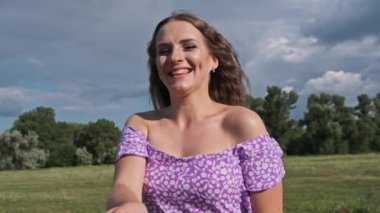 POV Happy young woman spinning and smiling at camera, slow motion. Couple holding hands, girlfriend joyful smiling and together turning around in nature. Portrait laughing girl has great time in love