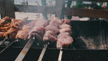 Doğadaki ızgarada şiş ızgarada barbekü yapmak. Terbiye edilmiş kebap mangal kömüründe kızartılır. Güneşli bir günde sahilde barbekü pişirme işlemi. BBC 'deki metal şişte lezzetli yemekler. Şişler açık