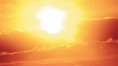 Dramatic sunset with sun rays in the Sky through orange layered clouds, Timelapse. Awesome epic cloud space. The big bright orange sun moves down over the horizon. Time Lapse. Amazing vibrant sundown